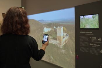 Frau steht mit Multimediaguide im Museum